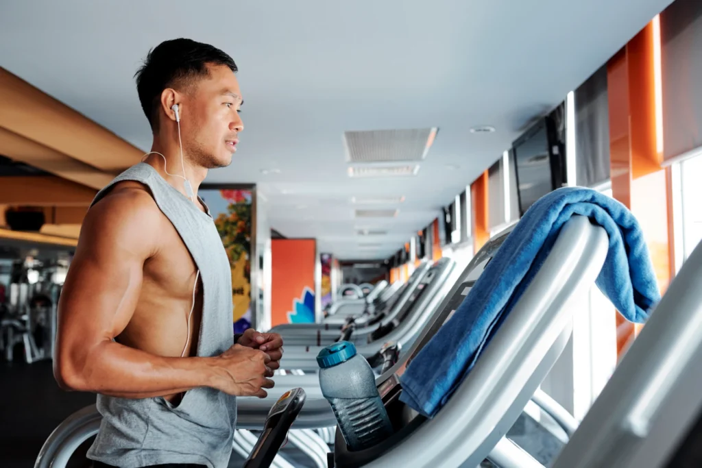 Mann trainiert konzentriert auf einem Laufband im Fitnessstudio während eines intensiven Intervalls.