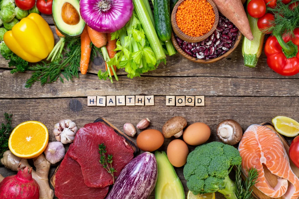 Vielfältige gesunde Lebensmittel auf einem Holztisch – Grundlage für eine ausgewogene Ernährung im Rahmen eines Longevity-Lifestyles.