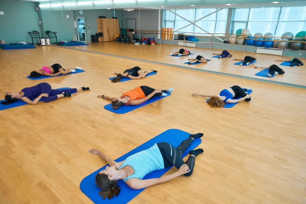 Frauen trainieren gemeinsam in einem Pilateskurs – Fokus auf Beweglichkeit, Körperbewusstsein und sanftes Muskeltraining im Studio