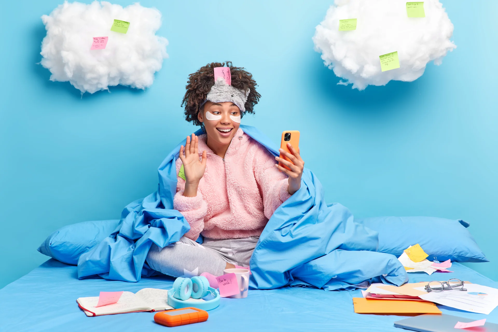 Frau im Bett mit Schlafmaske, Augenpads und Handy, Social-Media-Trend