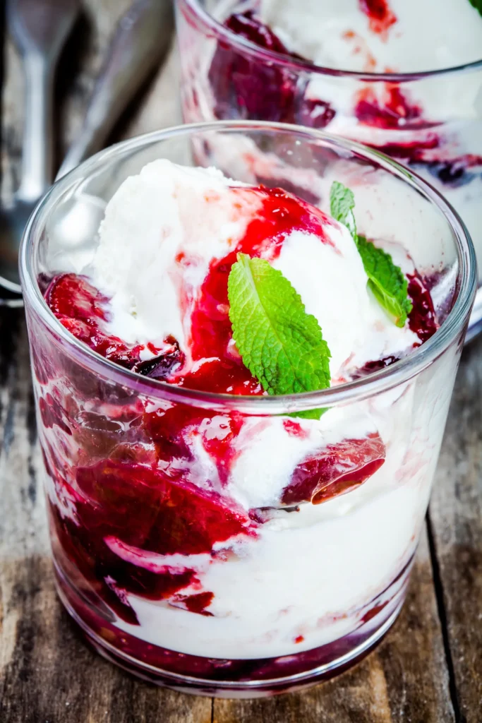 Mehrschichtiges Beeren-skyr-eis mit frischen Früchten und minze im Glas
