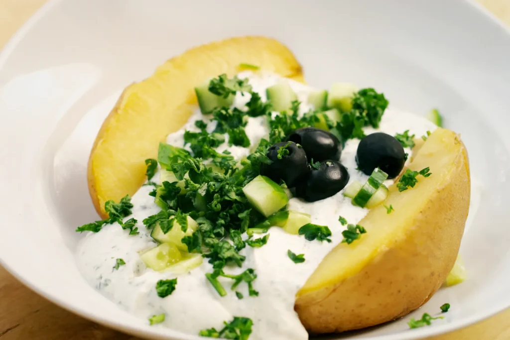 Ofenkartoffel mit cremigem Kräuterquark, Gurke und Petersilie als leichtes Gericht.