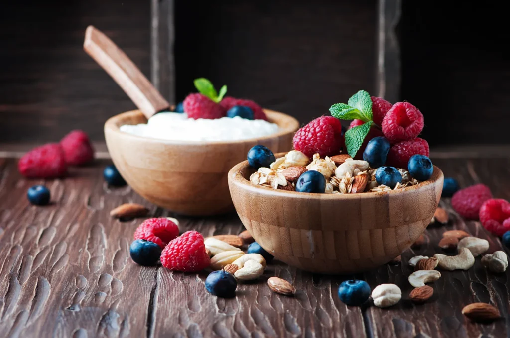 Glas mit Magerquark und frischen Beeren als proteinreicher Snack für zwischendurch.