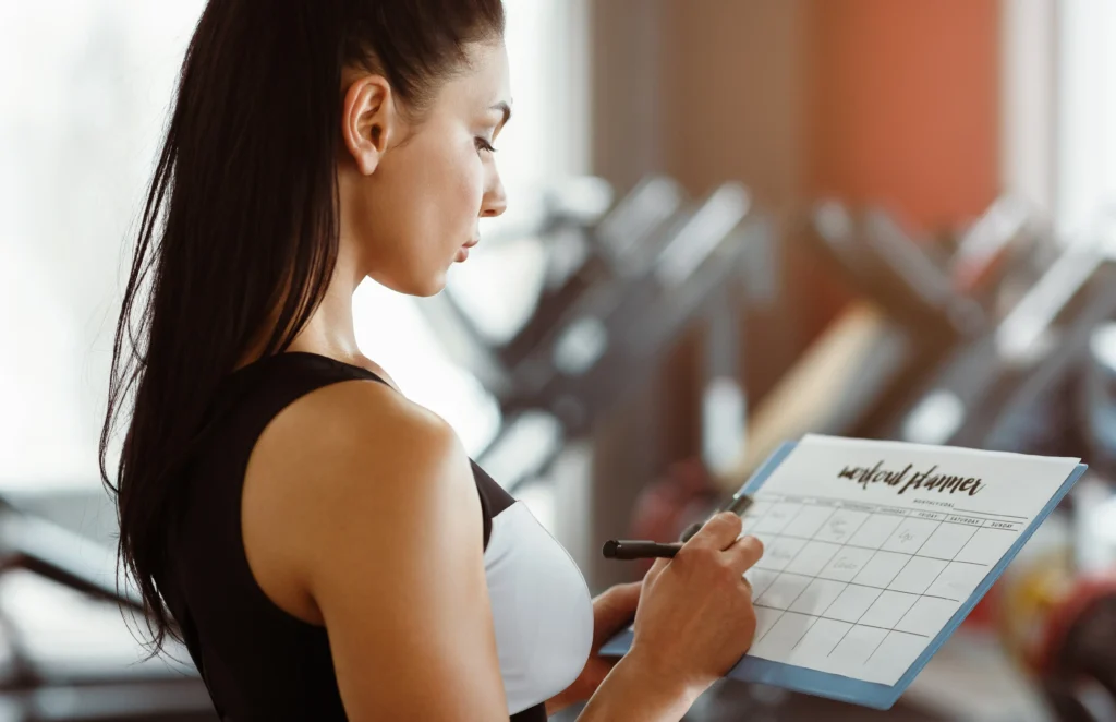 Personal Trainerin erstellt einen individuellen Trainingsplan im Fitnessstudio